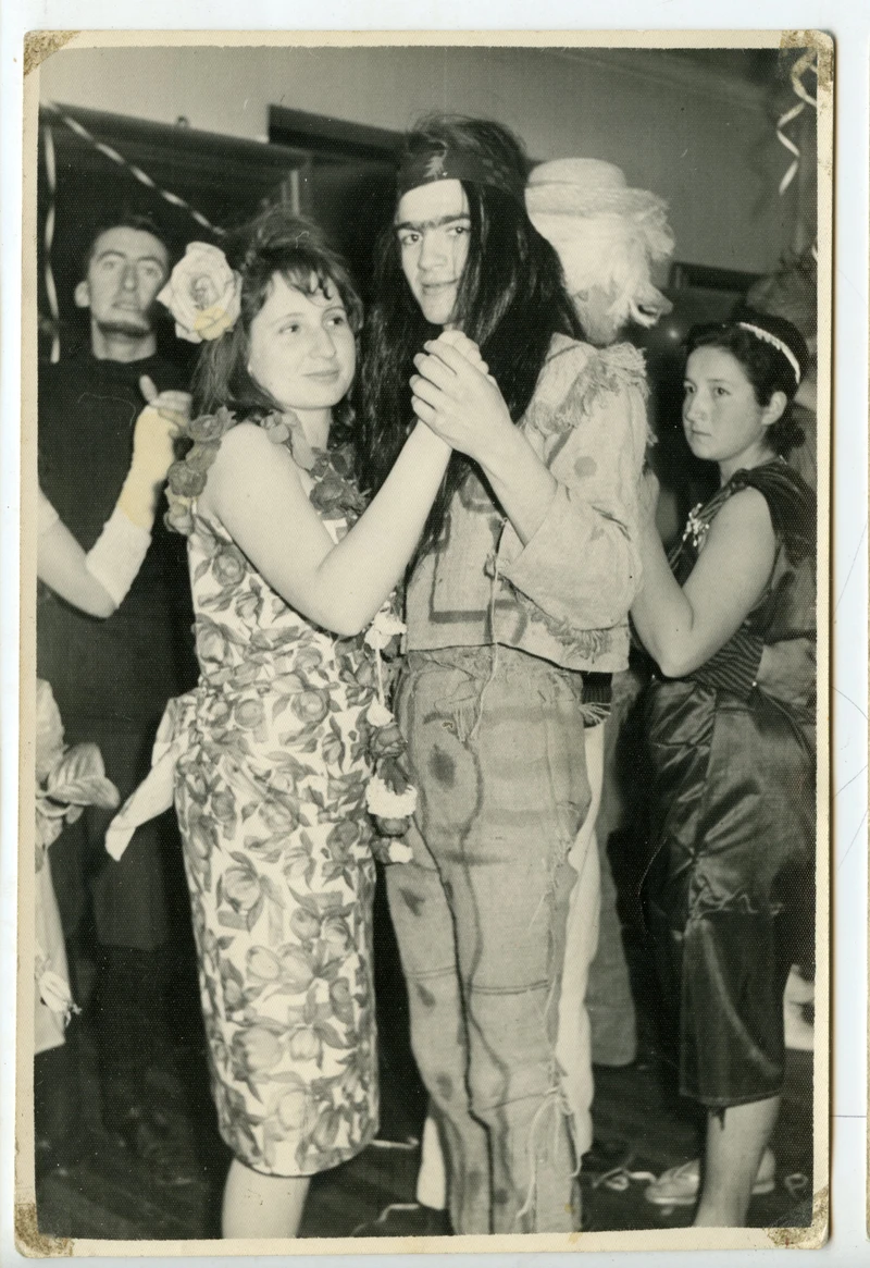 Pareja disfrazada bailando de la mano